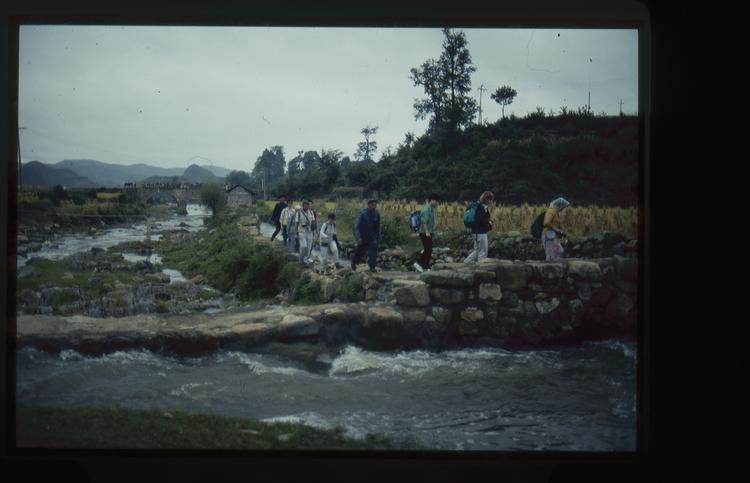 Image of 35mm slide: Thursday September 27th Members of the tour group walking to a village