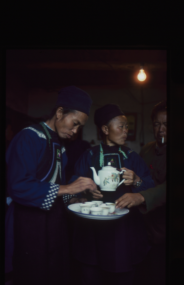 Image of 35mm slide: Inside a farmhouse. Tea being prepared for the group.