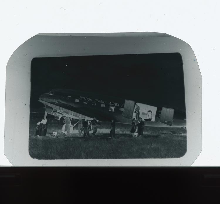 Image of Black and white negative of British Guiana Airways plane being loaded with people and objects