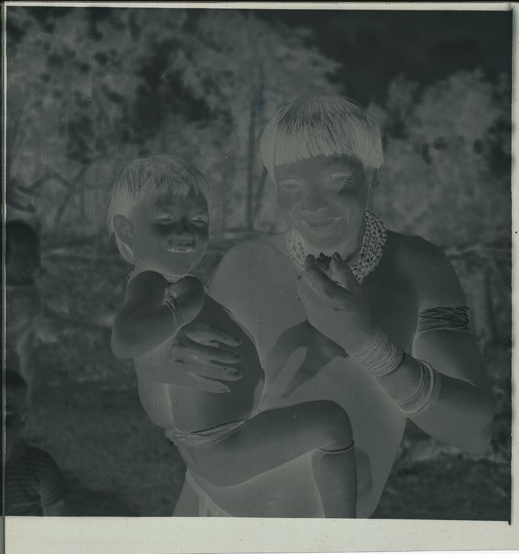 Image of Black and white negative of a Wai Wai adult holding small child