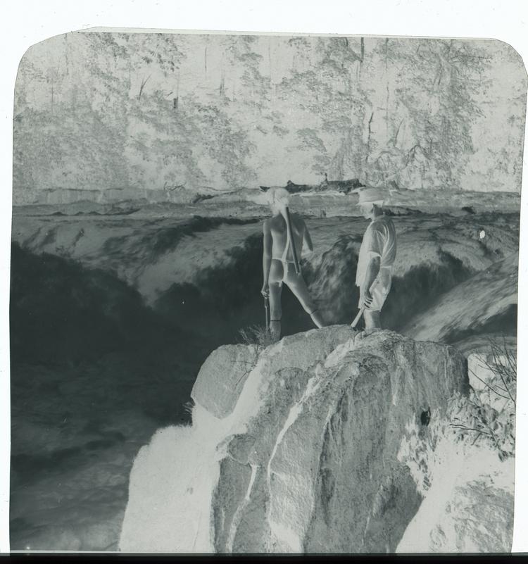 image of Black and white negative of Wai Wai person and expedition team member overlooking massive waterfalls