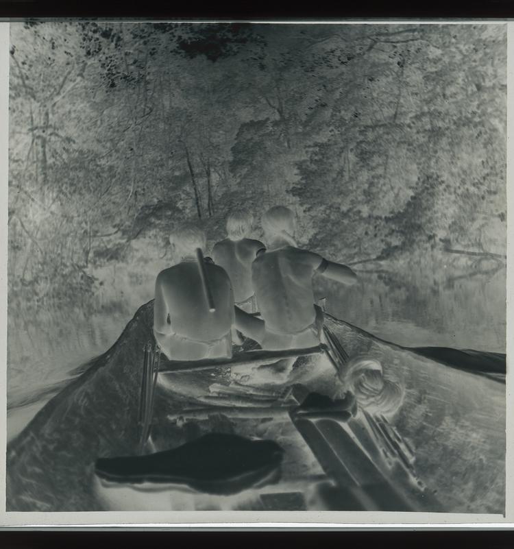 Image of Black and white negative of three Wai Wai tribes people in a canoe