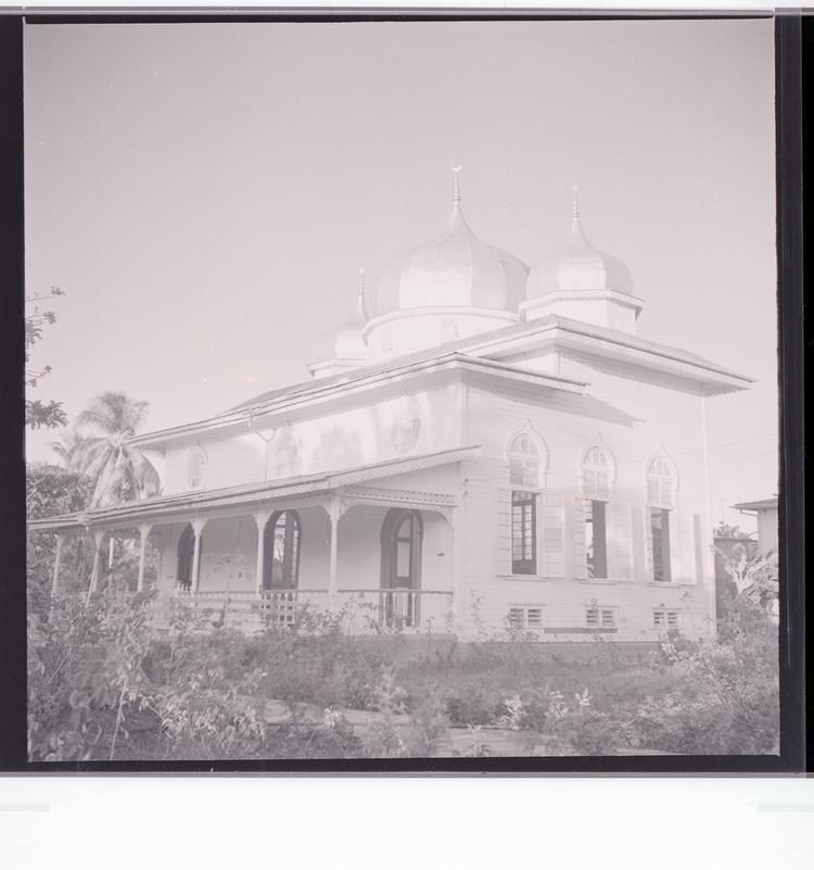 Image of Black and white negative view of building with rounded turrets, side view