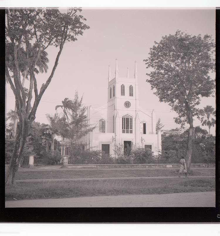 image of Black and white negative view of ornate church with multiple steeples and trees in front