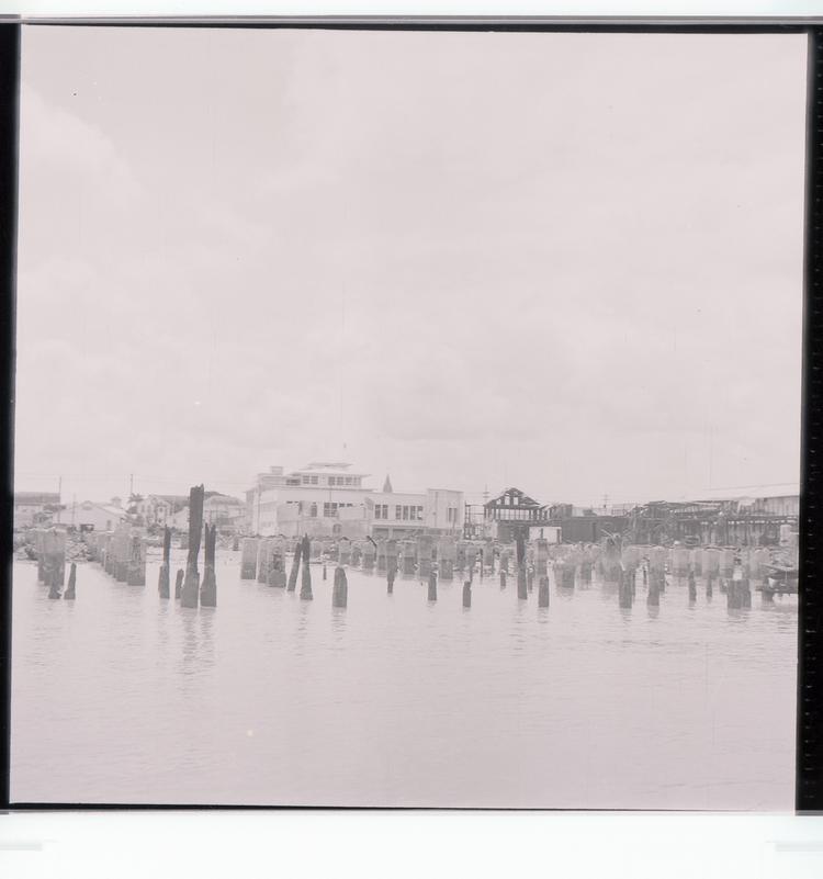 image of Black and white negative view of burned dockside buildings and harbour