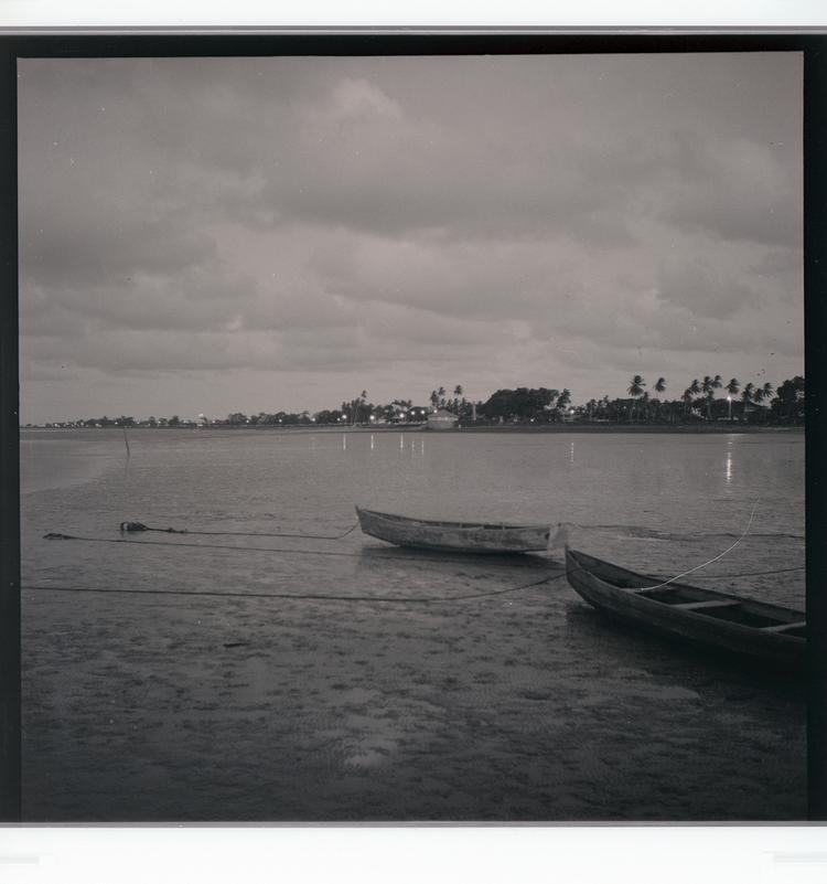image of Black and white negative of waterfront with boats as light is fading