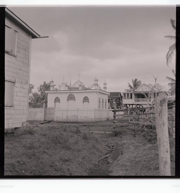Image of Black and white negative of somewhat ornate religious building in the middle of other buildings