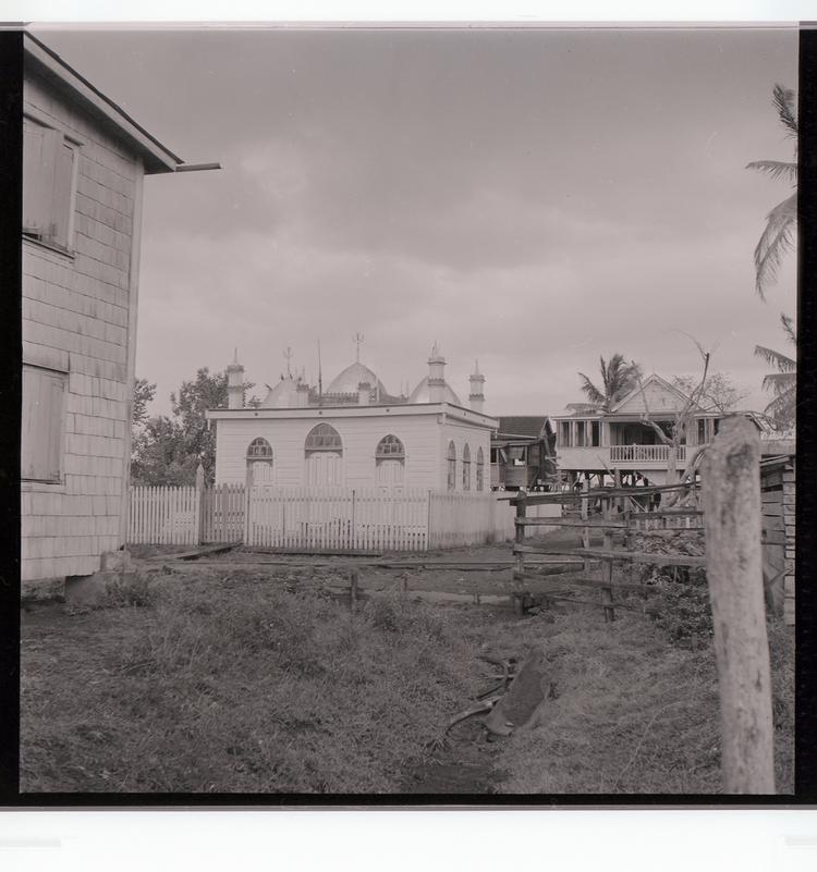 Image of Black and white negative of somewhat ornate religious building in the middle of other buildings