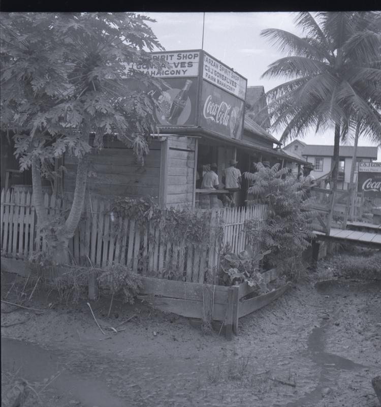 Image of Black and white medium format negative (scanned positive) of a shop with people at a bar