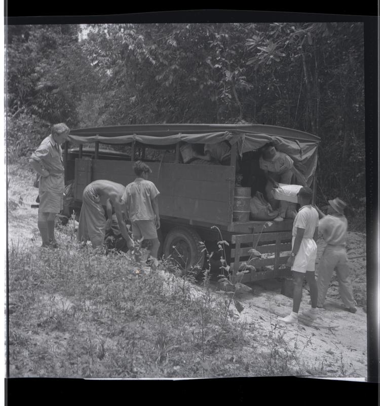 Image of Black and white medium format negative of five people around a vehicle