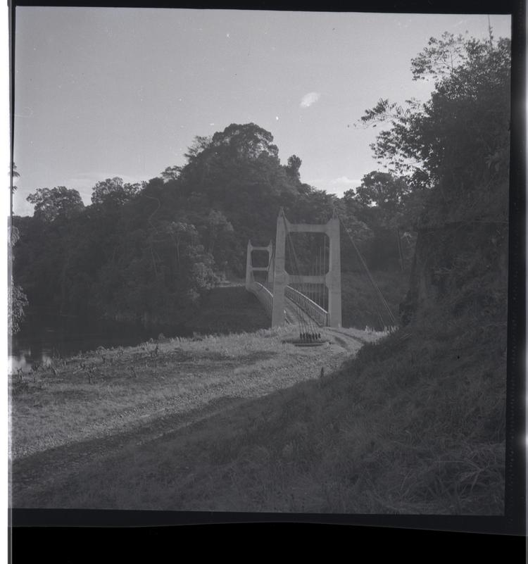 Black and white medium format negative of road leading to a bridge