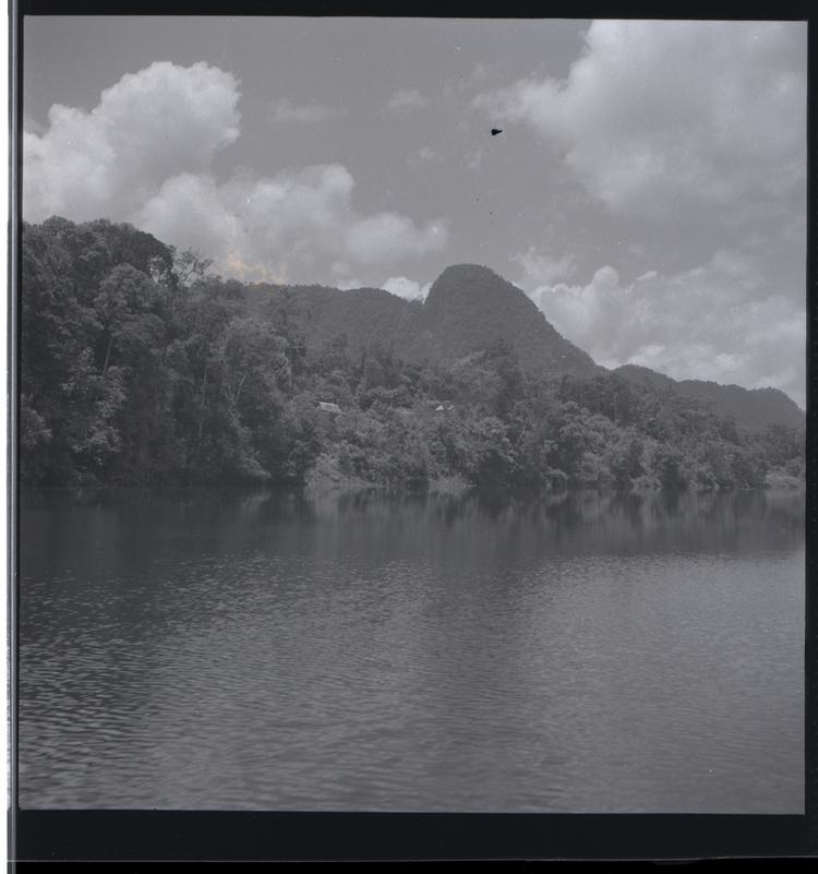 Black and white medium format negative of view of hill from river