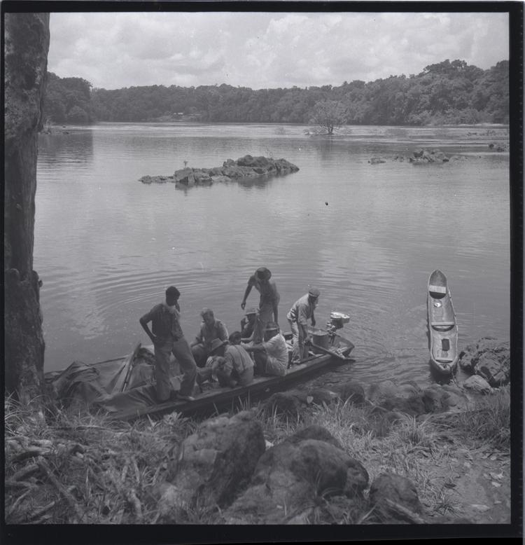 Black and white medium format negative of boat very full of people on a wide river