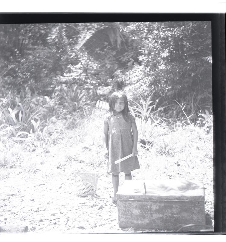image of Black and white medium format negative of Child in jungle clearing with trunk in foreground