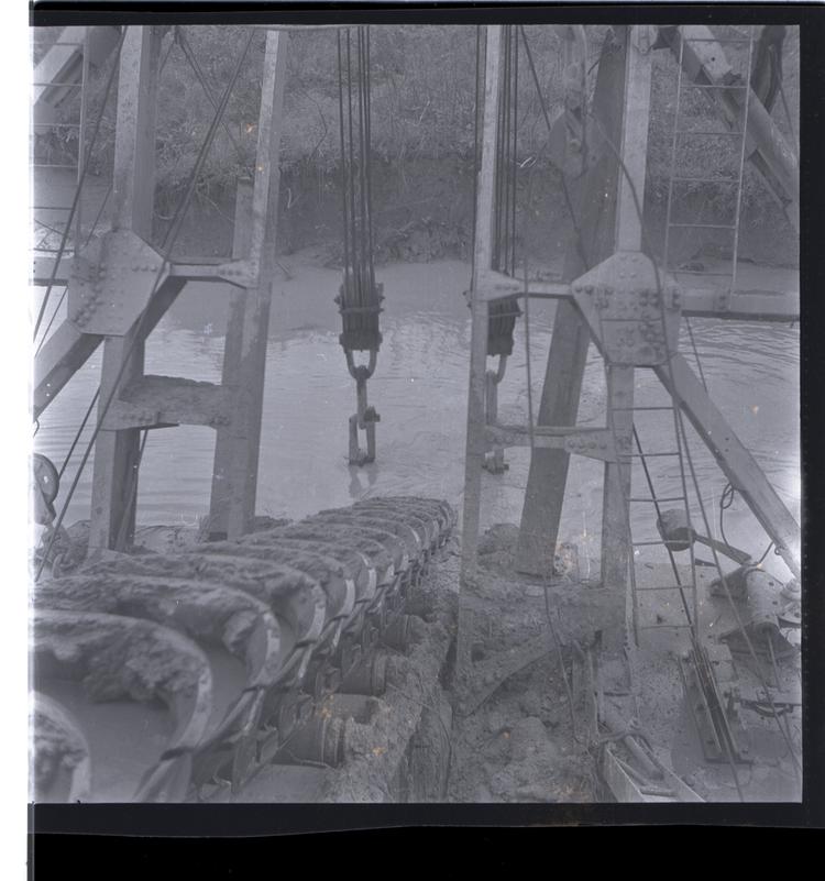 Image of Black and white medium format negative of Close up of industrial structure (pulleys and items being conveyed on a belt)