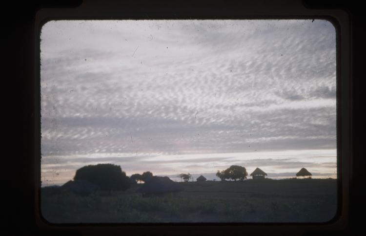 image of Colour slide of sunset wth trees and hut in distance