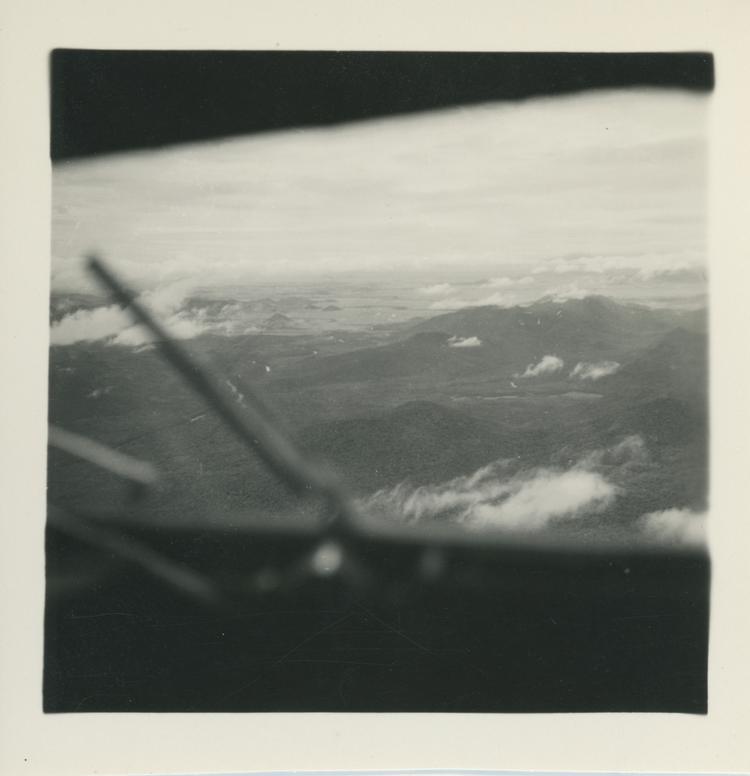 image of Black and white print of mountains and cloud through plane window