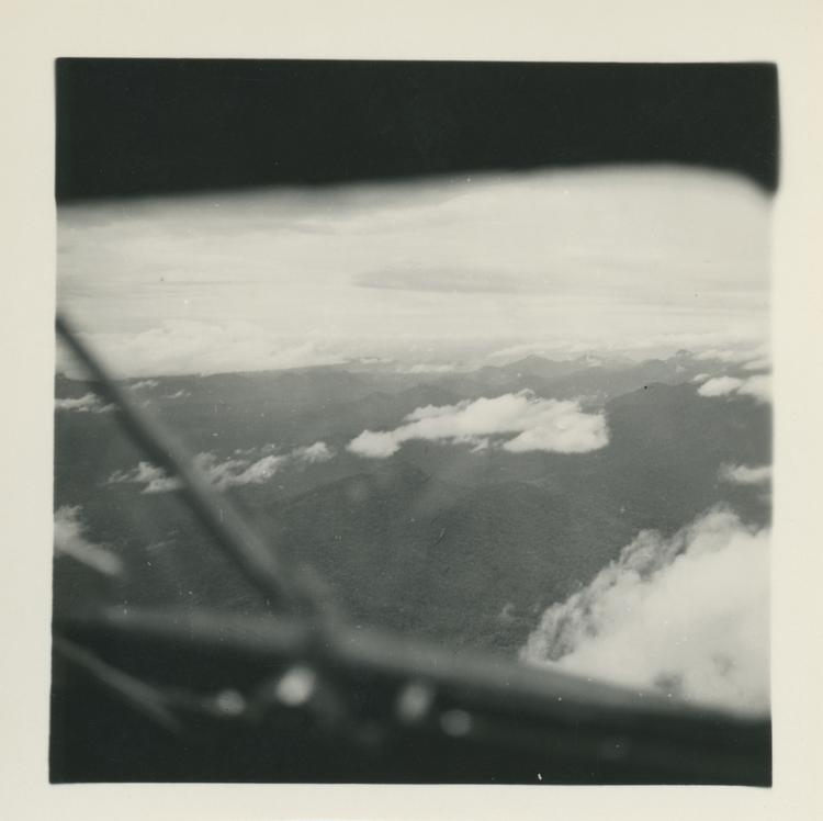 image of Black and white print of mountains and cloud through plane window