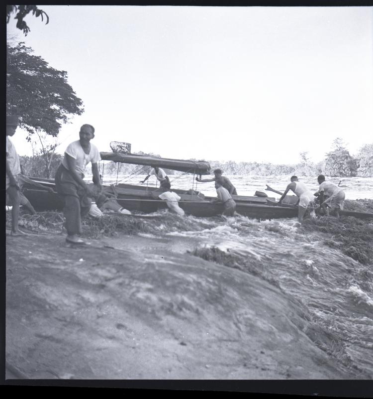 image of Black and white medium format negative of men in rapids moving boats