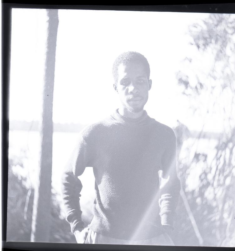 image of Black and white medium format negative of man standing with hands on hips (pale image)