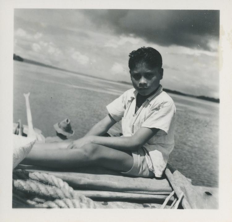 image of Black and white print of young boy on a boat