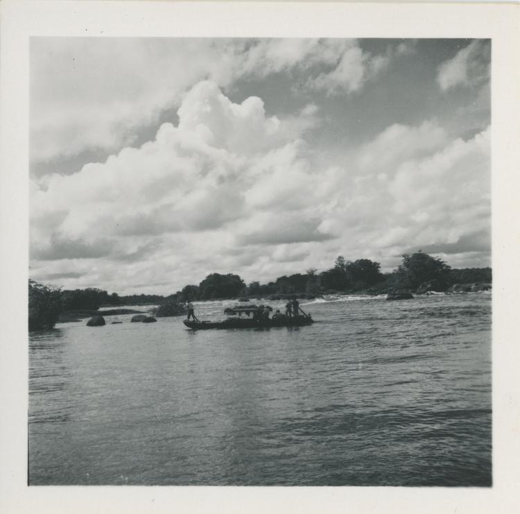 Image of Black and white print of boat on wide river quite close to shore