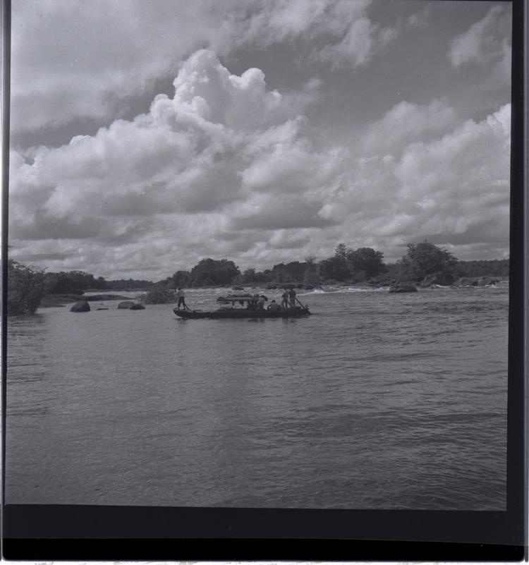 Image of Black and white medium format negative of boat on wide river quite close to shore