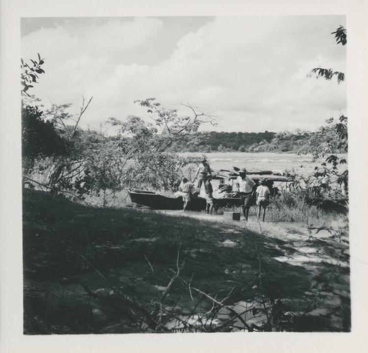 Image of Black and white print of men busy around moored boat