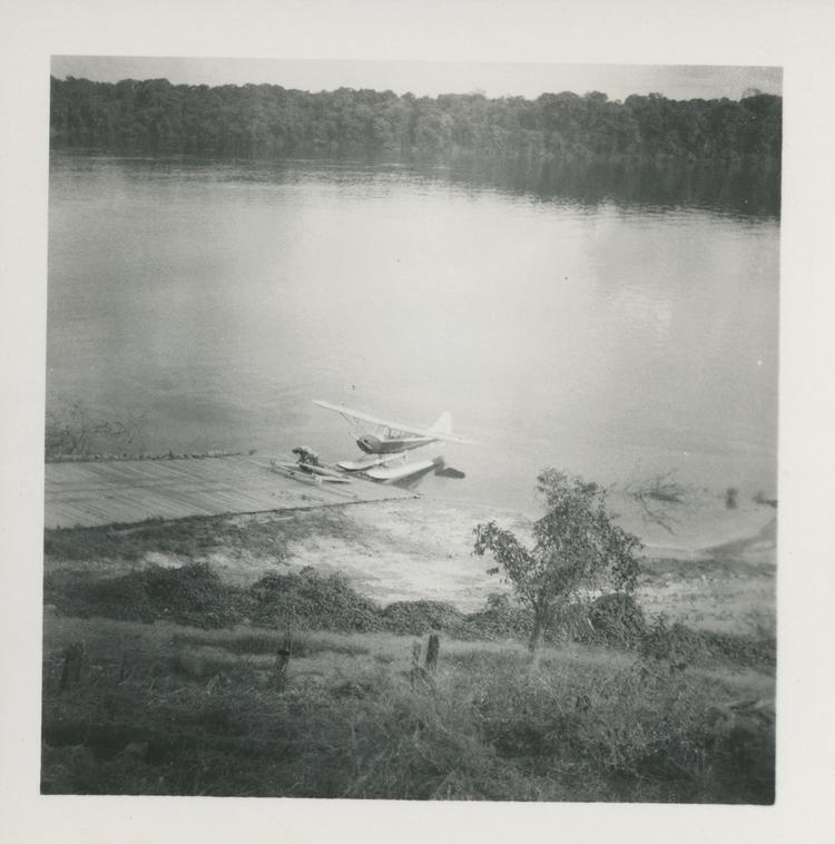 image of Black and white print of seaplane on river by jetty