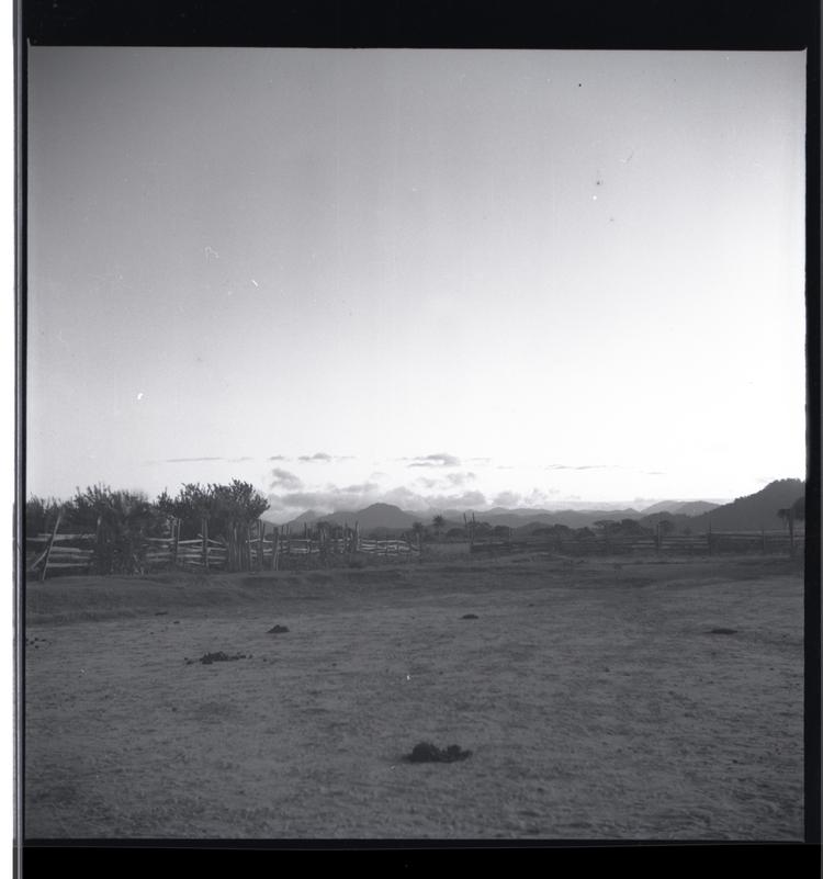 Image of Black and white medium format negative of landscape with trees, hills and clouds in distance