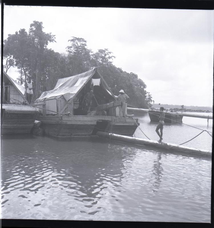 Image of Black and white medium format negative of large boat with awning being loaded