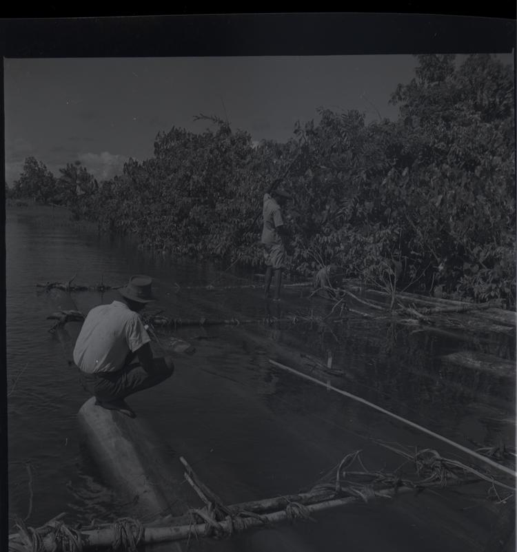 Image of Black and white medium format negative of 3 men working on a raft