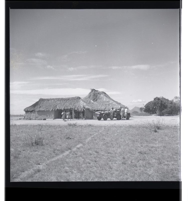 Image of Black and white medium format negative of buildings with jeep in front