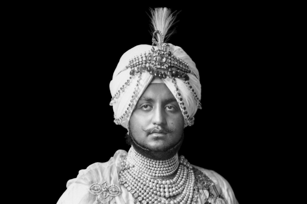 A man sat in an ornate outfit and turban