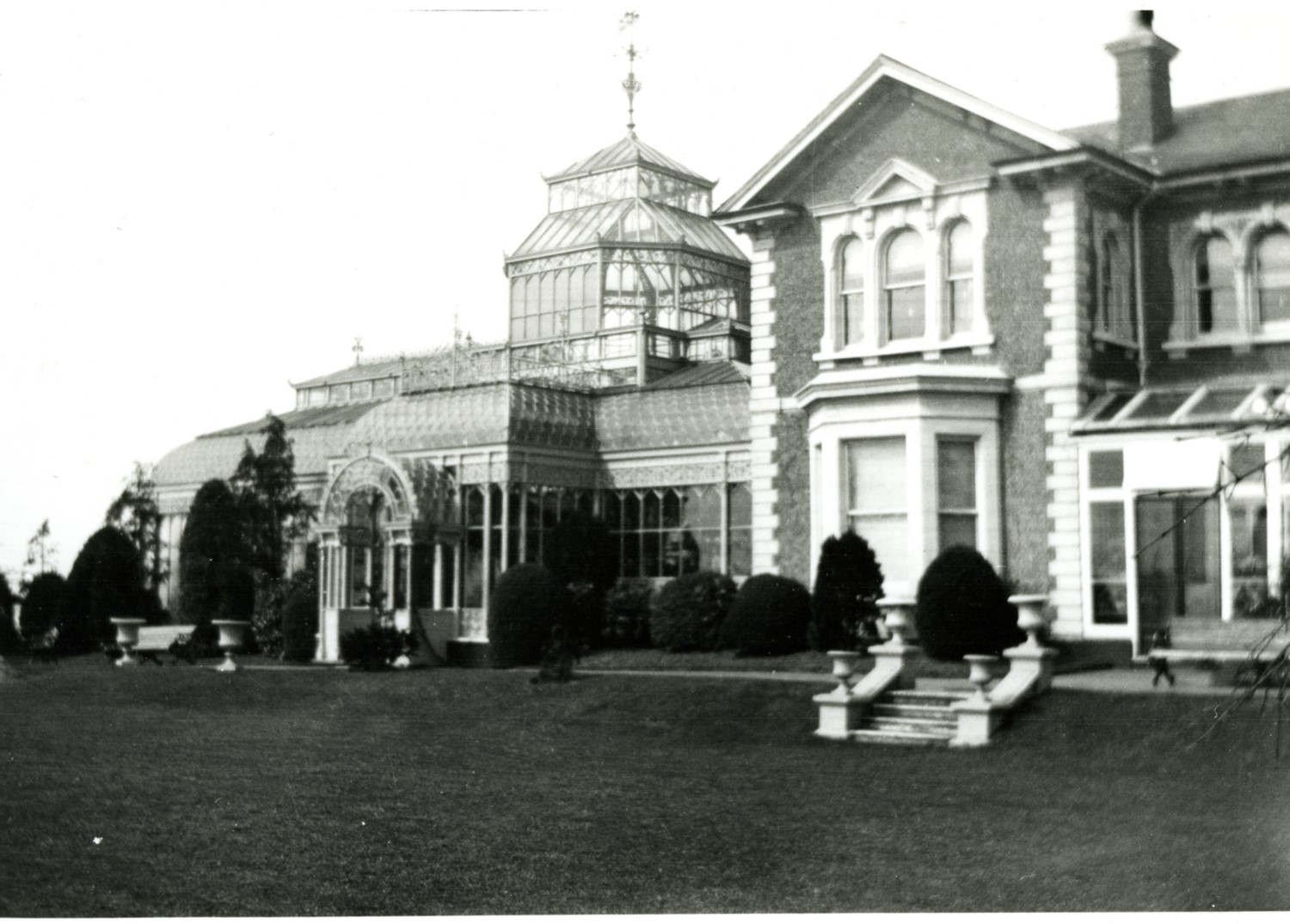 A large house with conservatory at the side.