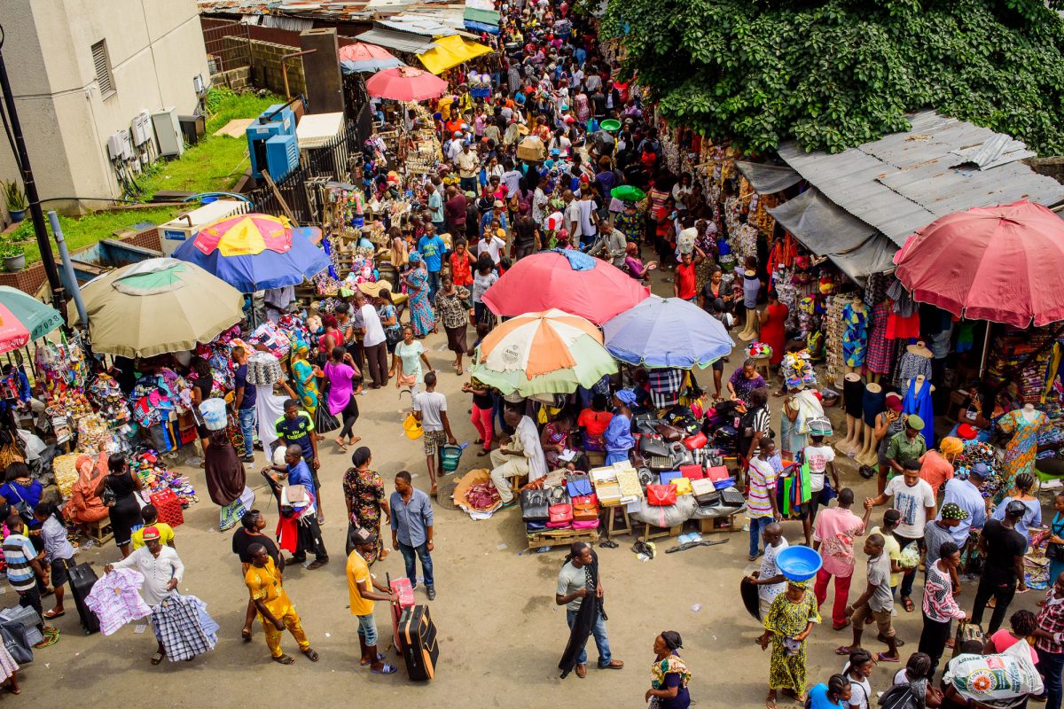 Busy street market with lots of parasols.