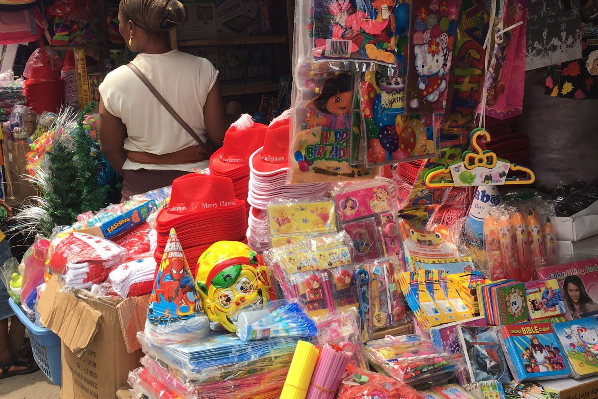 Market stall with colourful toys and children's backpacks.