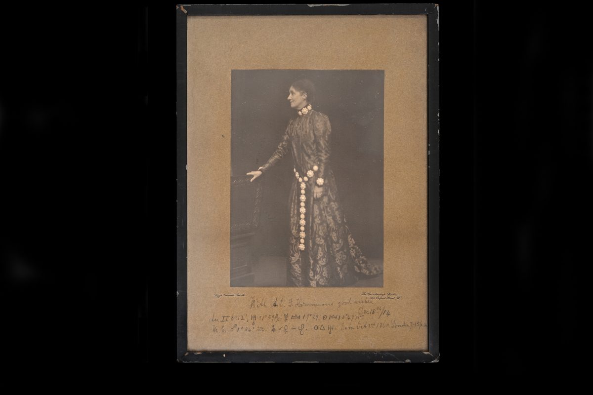 Woman in period dress with Long chain around hip.