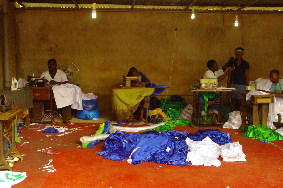 image of people using sewing machines in room with fabric on the floor.