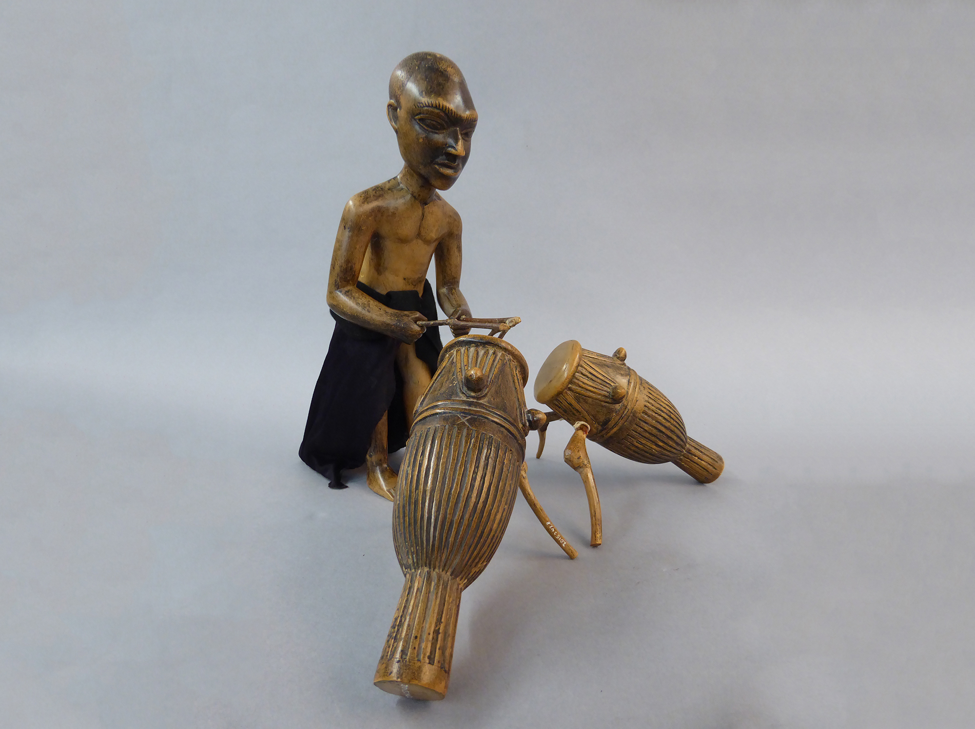 Figure of a man playing drums.