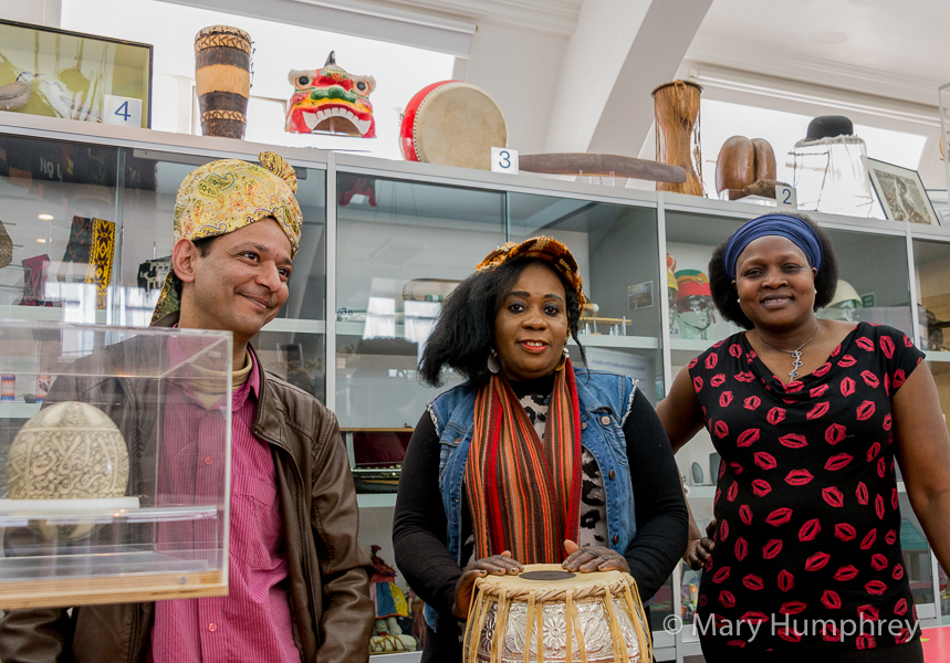 Three people standing in front of objects