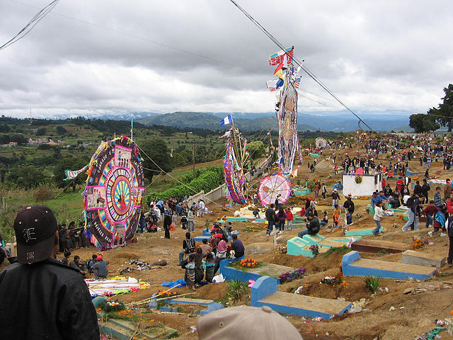 People outside with large kites.