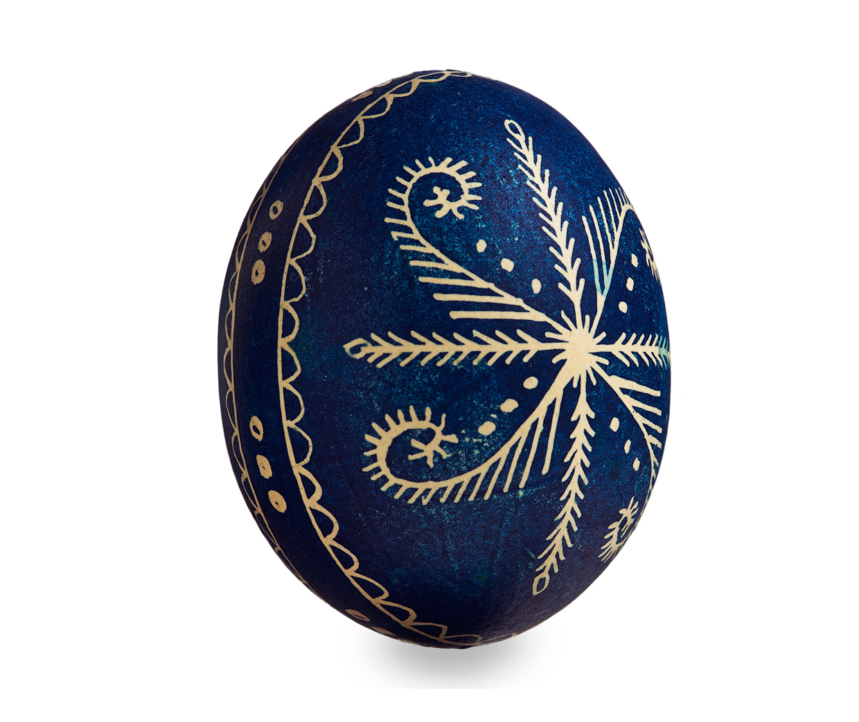 Blue egg with design carved into it that looks like a flower.