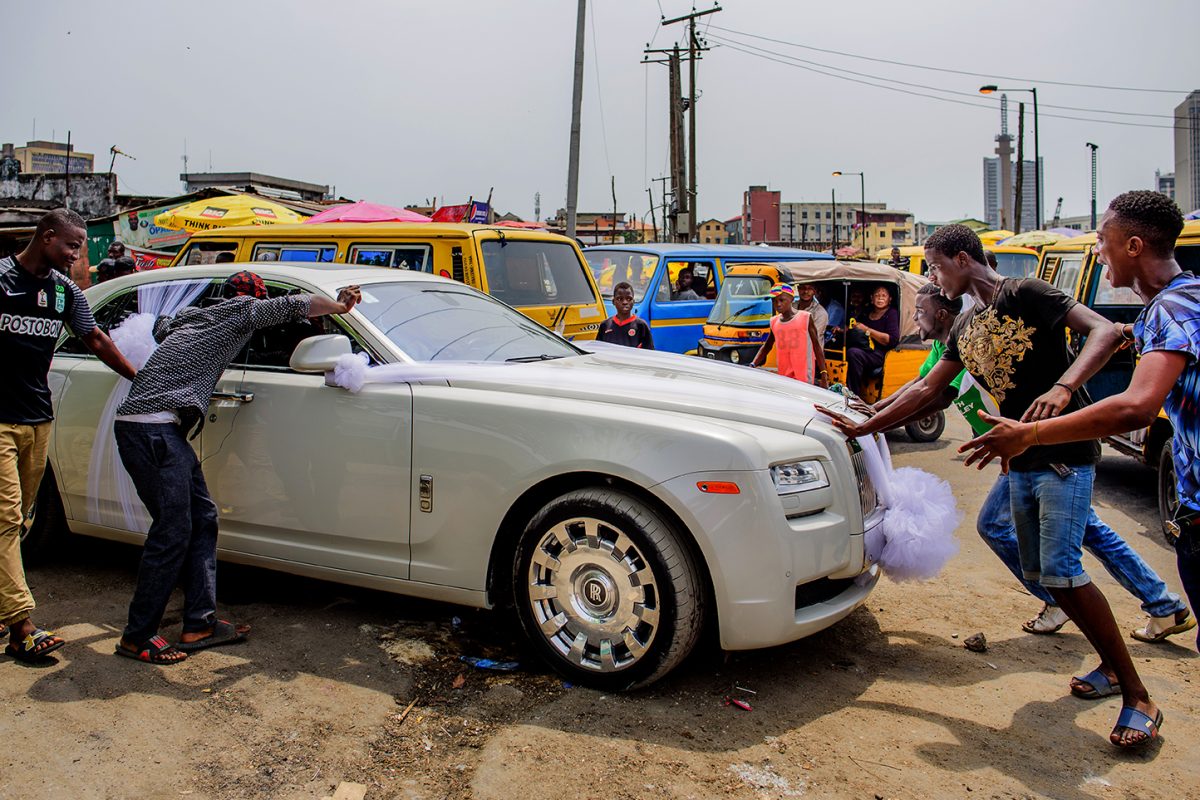 People push on a white wedding car