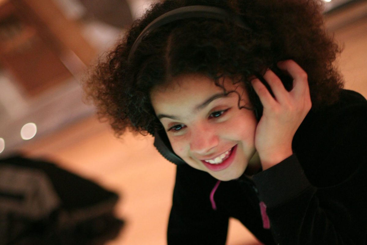 girl listening to Music Gallery tables with headphones on