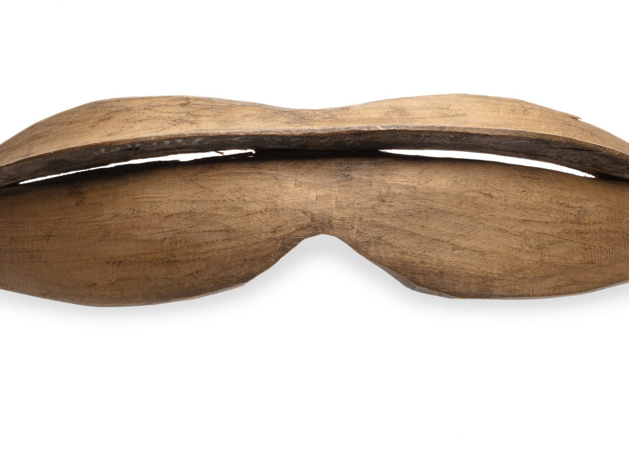 Wooden snow googles, shaped like bean pod with slit in middle for visibility