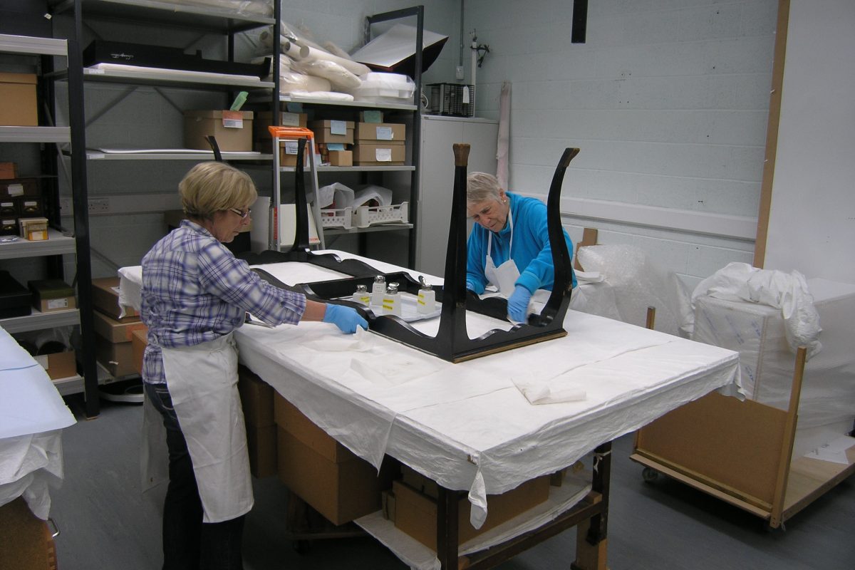 two conservators cleaning the clavichord