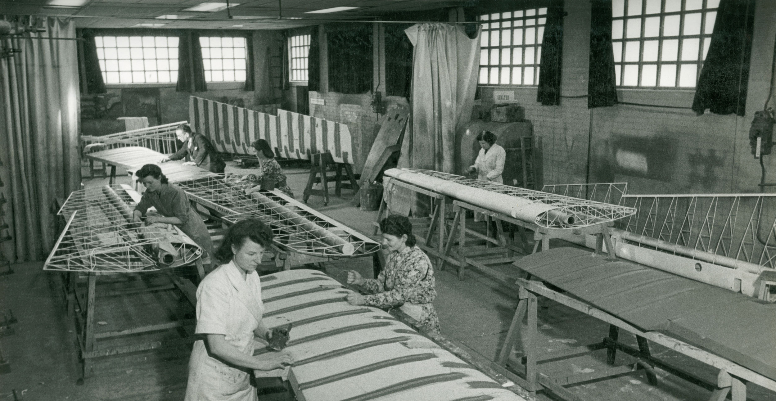 Black and white image of people working on panels.