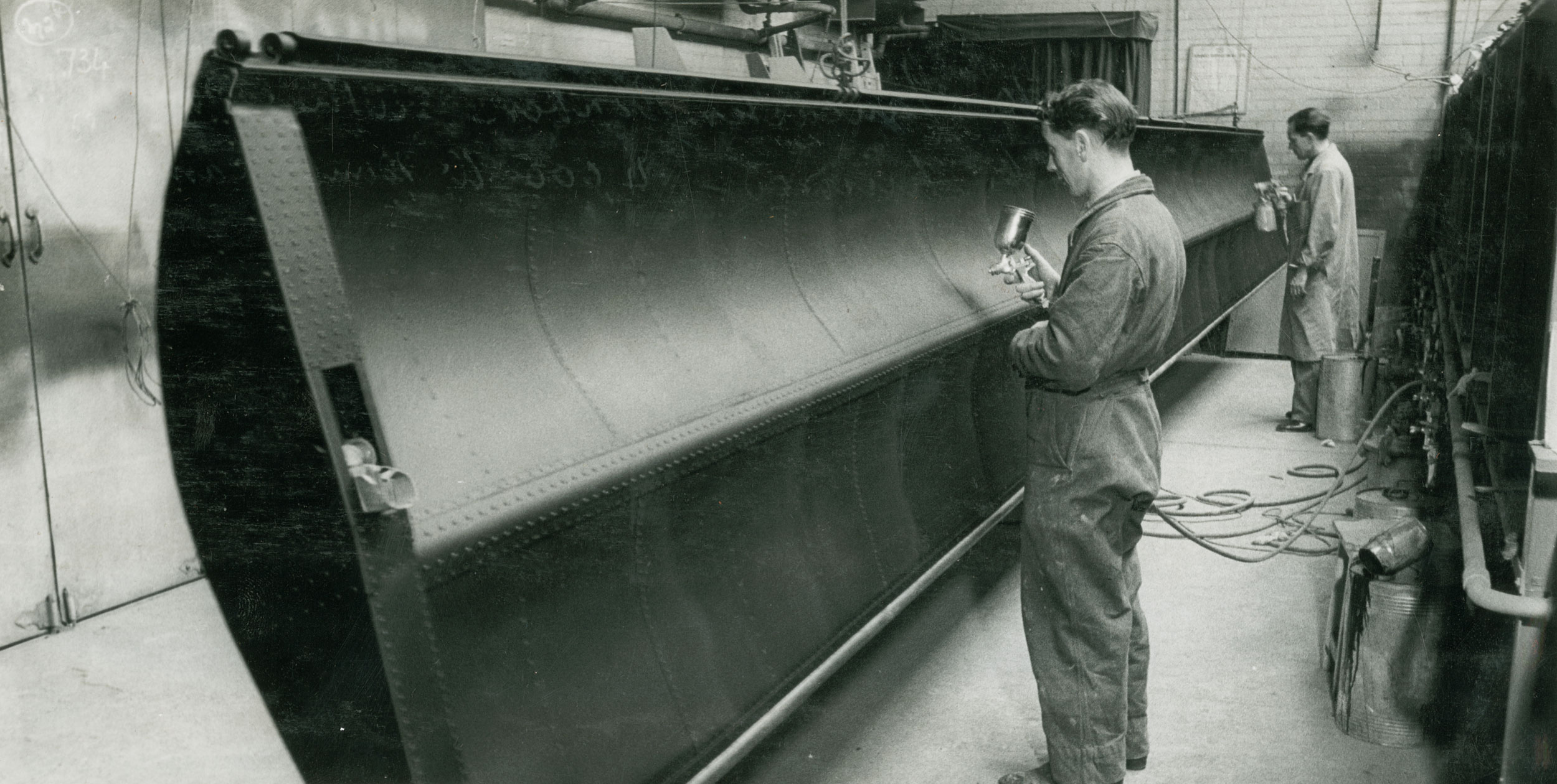 Black and white image of man working on door.
