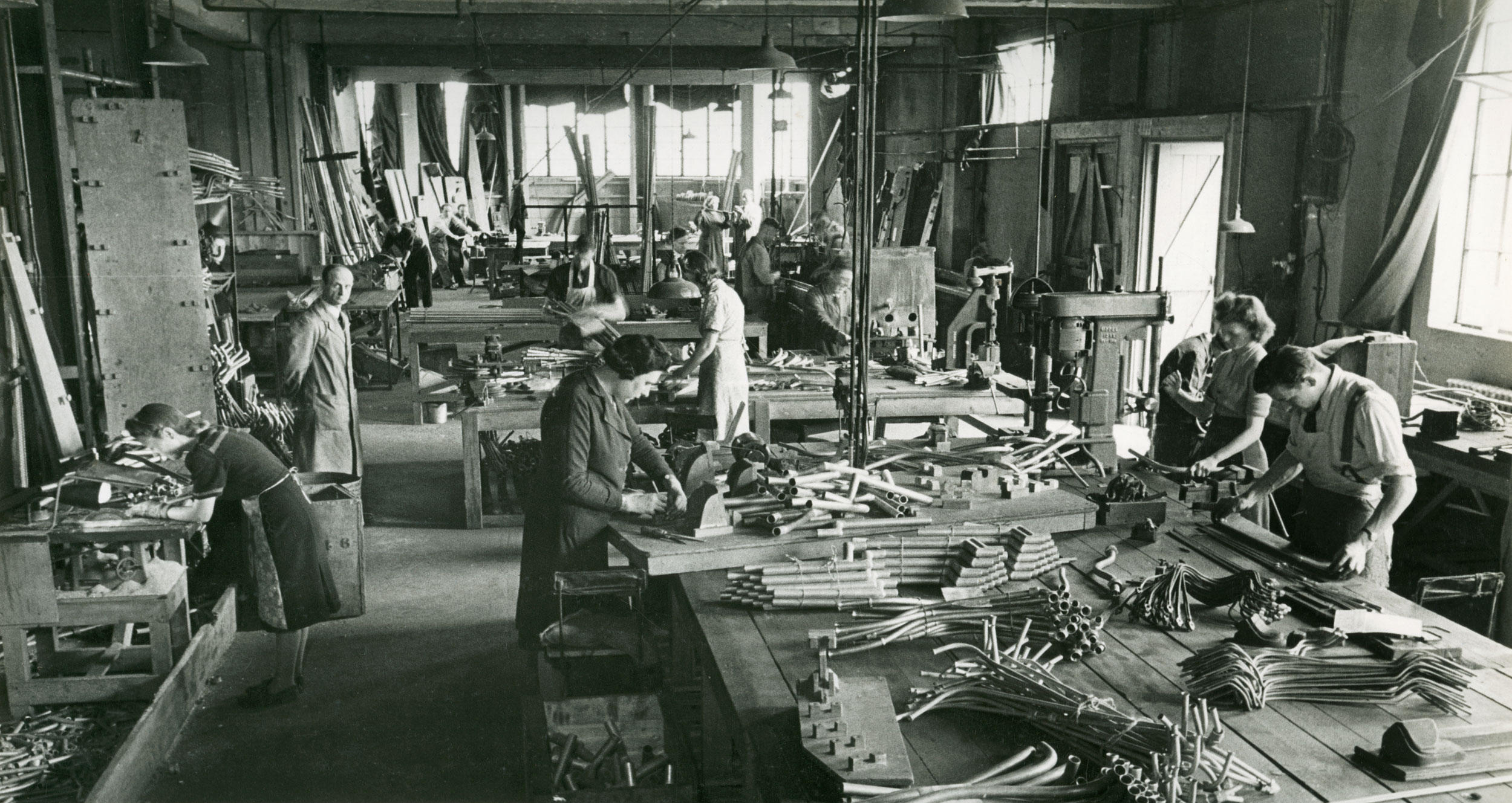 black and white image of people making pipes.